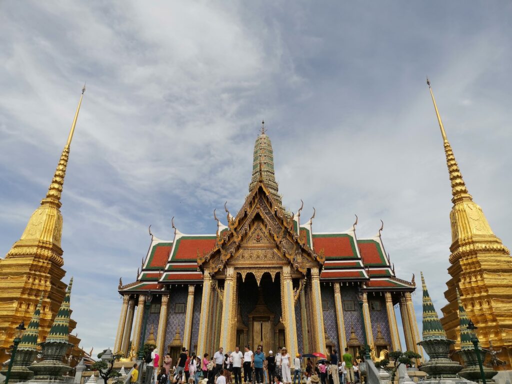 Wat Phra Kaew people walking on street near brown and green concrete building during daytime